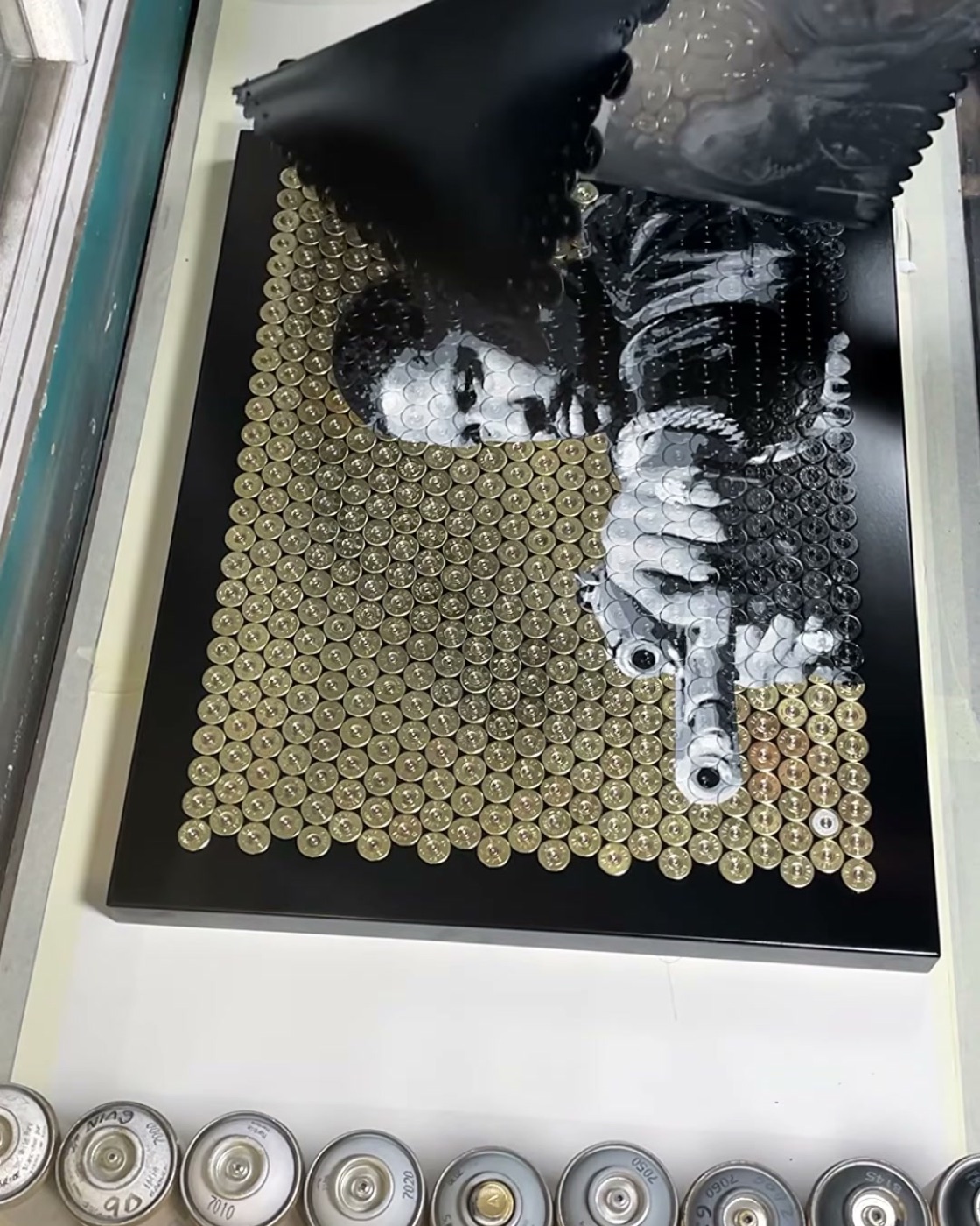 Peeling the stencil back to reveal the portrait