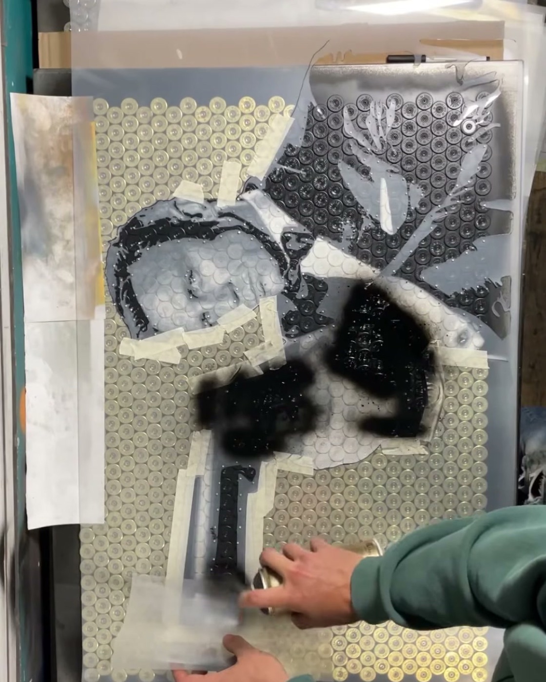 Laying the hand-cut stencil over the brass